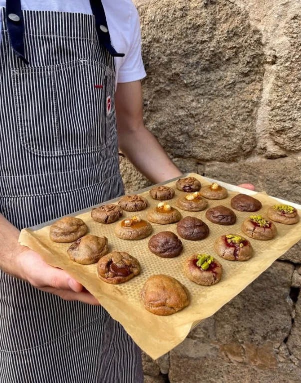 Une plaque de cookies tenue devant un mur de granit